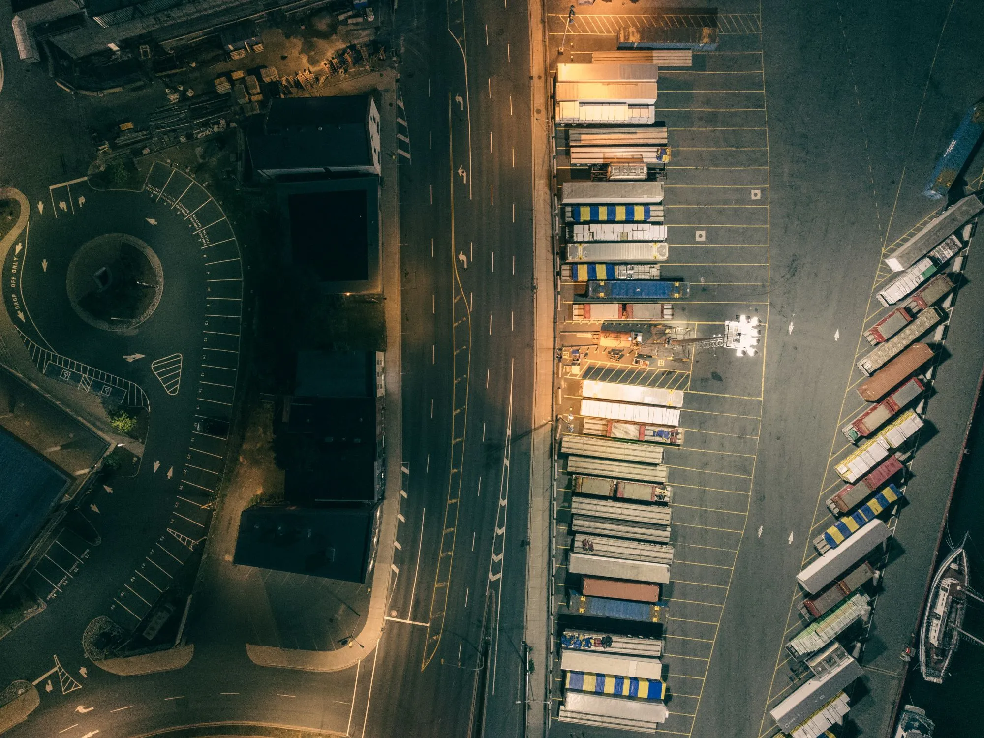 A freight terminal working after dark, trailers lined against the dock